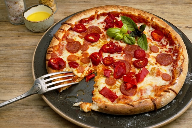 Talheres ao lado de pizza
