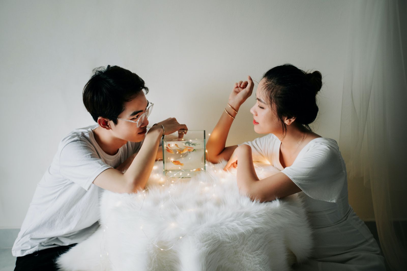 Homem e mulher conversando em uma mesa com um aquário.
