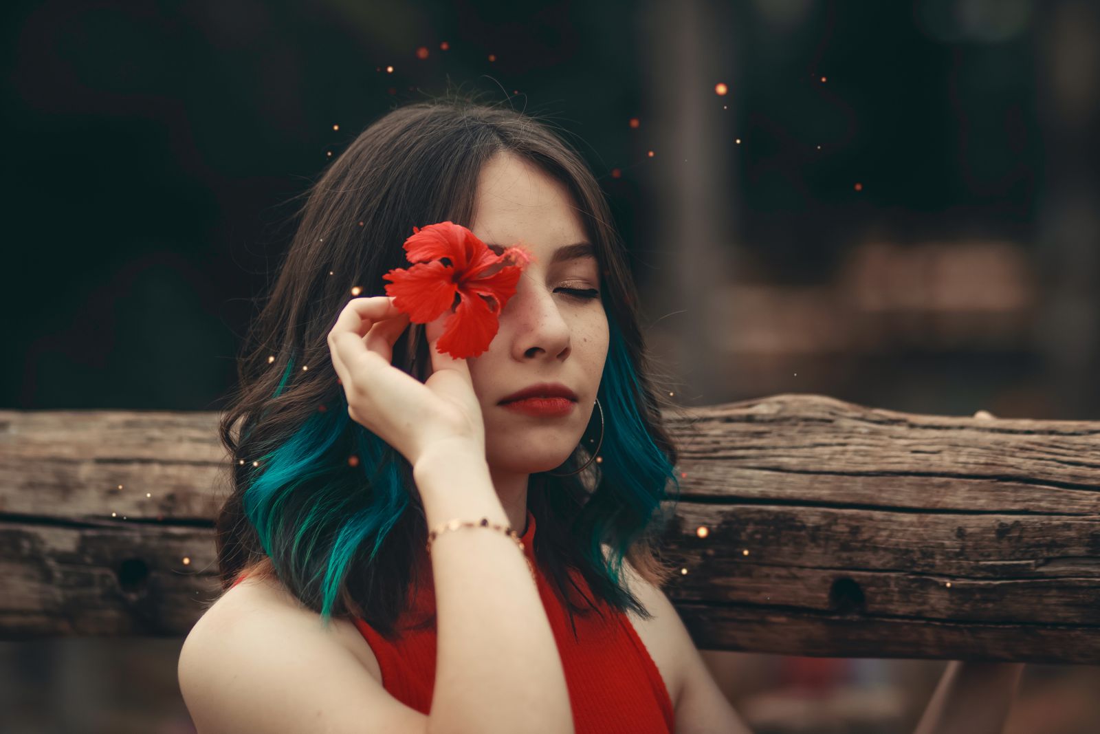 Retrato de uma mulher com uma flor sobre um dos olhos.