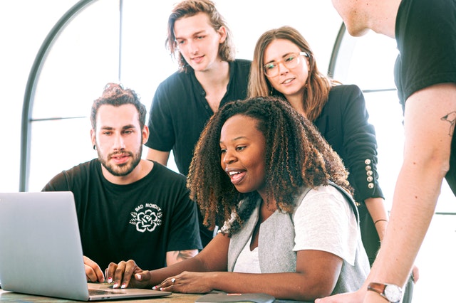 Equipe olhando chefe trabalhar em notebook